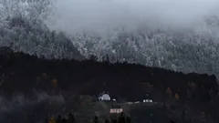 Mlžná hora s domem v popředí za mlhavého počasí
