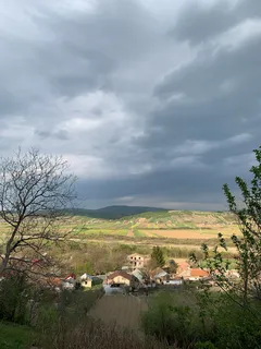 Oblačné nebe nad vesnicí s zelenou trávou během dne