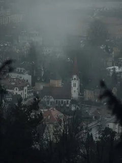 Mlhavý pohled na město s hodinovou věží